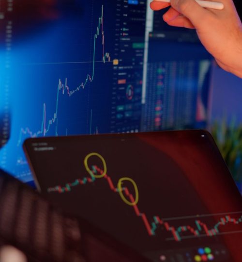A person analyzes cryptocurrency market trends on multiple screens with graphs.