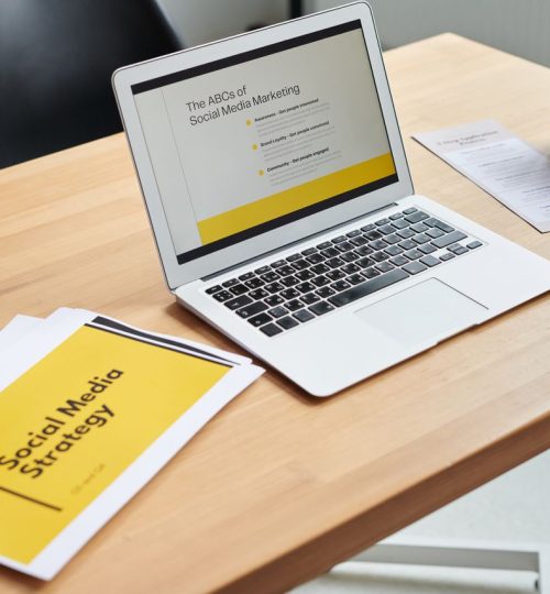 Close-up of a laptop showing a social media marketing strategy in an office setting.